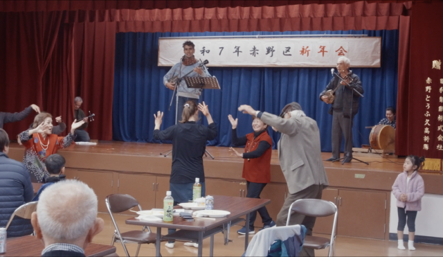 Photo of the event, showing Ema playing on stage, and people dancing in front of the stage
