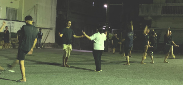 Eisa training at night. Ten dancers are seen Eisa training at night. Ten dancers are seen